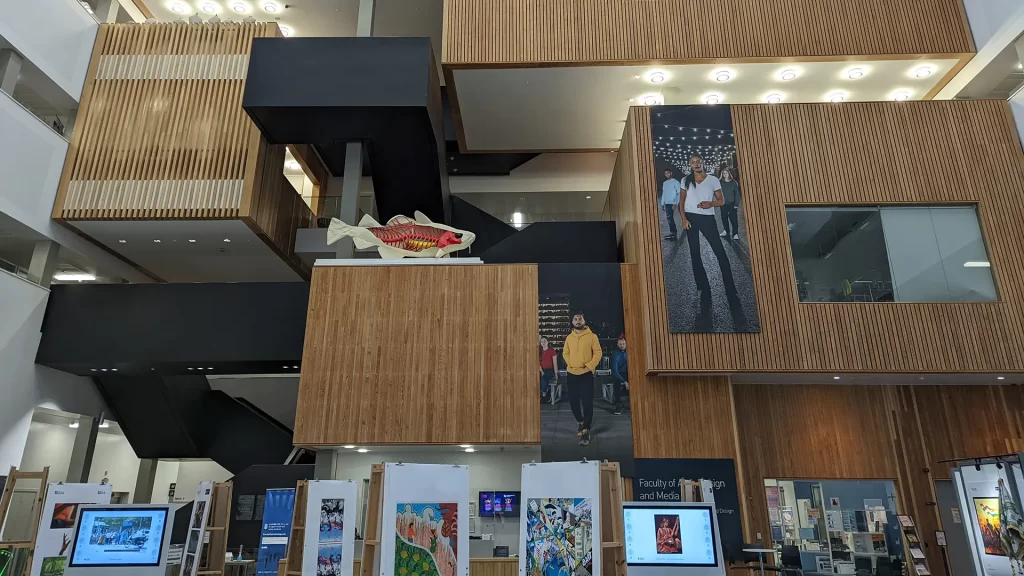 Modern bronze-toned architectural atrium of a major UK higher education business faculty, reflecting Braddan's experience in enterprise-scale business analysis and consultancy